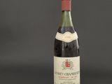 a bottle of red wine sitting on top of a black table