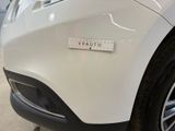 a close up of a white car with a ruler on it ' s bumper