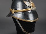 an old helmet on a black mannequin head on a black surface
