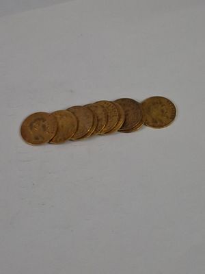 a pile of coins sitting on a table next to a cell phone
