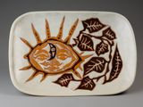 une assiette blanche ornée d'un motif marron et orange