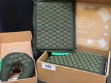 Trois boîtes contenant divers objets sont posées sur une table devant un fond noir.