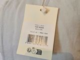 a tag on a pillow that is hanging on a wall