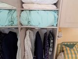 une photo d'une chambre avec une armoire remplie de vêtements