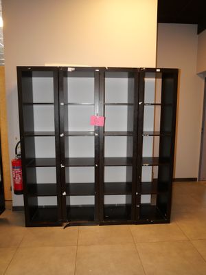 une bibliothèque noire aux portes vitrées, au milieu d'une pièce