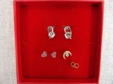 deux paires de boucles d'oreilles dans une boîte rouge posée sur une table