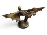 bronze figurine of a flying bat on a white background