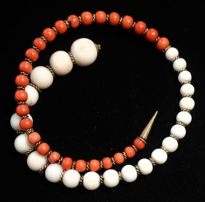 un gros plan d'un bracelet en perles orné d'une flèche