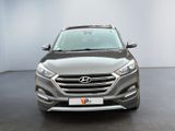 the front view of a gray car parked in a showroom