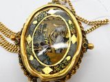 une photo d'un collier en or sur lequel figure le portrait d'une femme