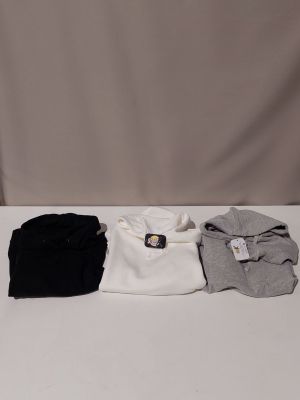 une table blanche sur laquelle sont posées trois paires de chemises noires et blanches