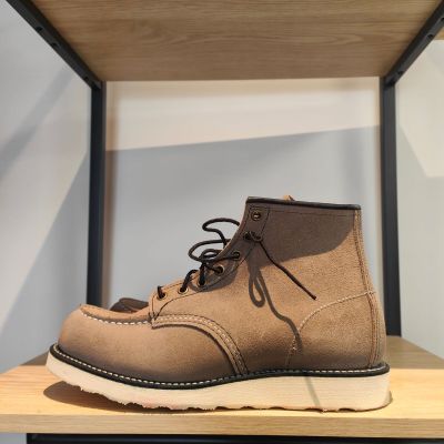 un gros plan sur une paire de bottes marron posées sur une étagère