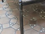 a wooden table with metal legs on a tiled floor