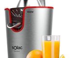un gros plan d'un presse-agrumes à côté d'un verre de jus d'orange