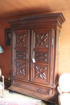 a wooden armoire in the corner of a living room
