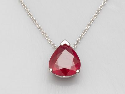 un gros plan d'un collier orné d'une pierre rouge en forme de larme