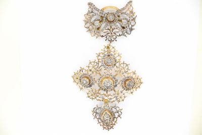 two pieces of jewelry that are hanging on a wall