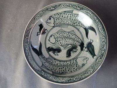 une assiette bleue et blanche ornée d'un motif de poisson