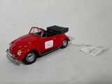 a red toy car with a black roof and a tag attached to it