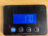 a digital clock on a table with a charger