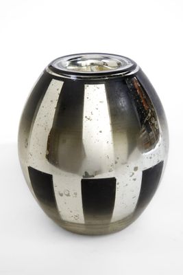 un vase noir et blanc posé sur une surface blanche