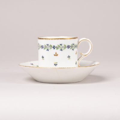 une tasse et une soucoupe ornées de fleurs et de feuilles