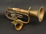 an old brass trumpet sitting on top of a black surface