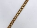 a close up of a gold bracelet on a white surface