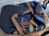 a blue and tan bag sitting on a counter