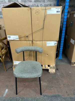 une pile de cartons et une chaise au milieu de la rue