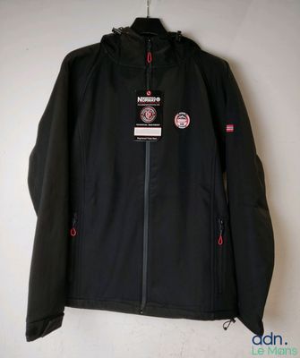 un gros plan d'une veste noire accrochée à un mur