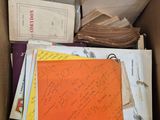 une boîte remplie de livres et de papiers sur lesquels il y a des inscriptions