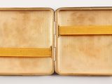 an open suitcase with a yellow handle on a white surface