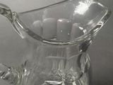 a clear glass pitcher that is sitting on a table