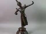 bronze statue of a woman holding a sword on a pedestal