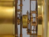a gold clock that is sitting in a glass case