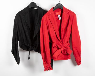 two red and black jackets hanging on a white wall