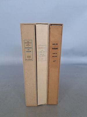 trois livres sont empilés sur une table