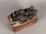 statue of a man and a woman on a horse on a wooden block