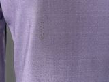 the back of a woman ' s purple sweater with long sleeves