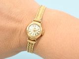 an image of a woman ' s wrist with a watch on it