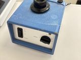 un petit objet bleu posé sur une table à côté d'un ordinateur portable