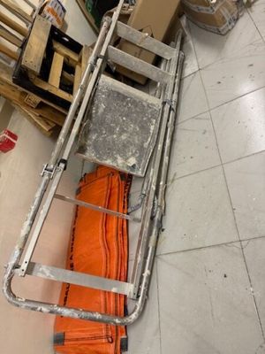 une échelle posée par terre à côté d'une pile de cartons