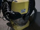une machine jaune posée par terre près d'un mur