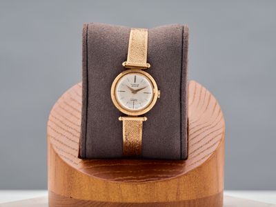 a watch that is sitting on top of a wooden stand