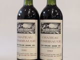 deux bouteilles de vin rouge posées l'une à côté de l'autre sur une surface blanche