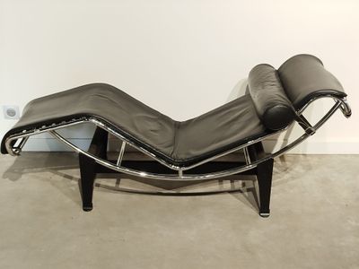 an image of a black leather chaise lounger in a white room