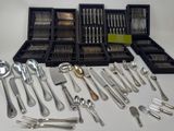 a lot of silver spoons and forks on the table