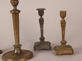 three different types of candlesticks sitting next to each other on a table