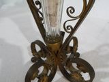 un vase en verre avec une bougie à l'intérieur sur un support